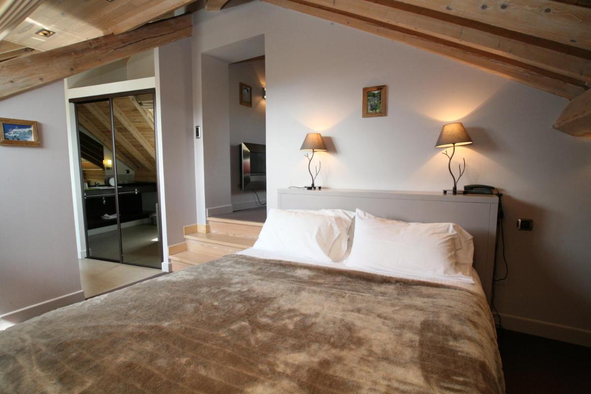 une chambre avec un grand lit avec des oreillers blancs dans l'établissement Hotel Corrieu, à La Llagonne