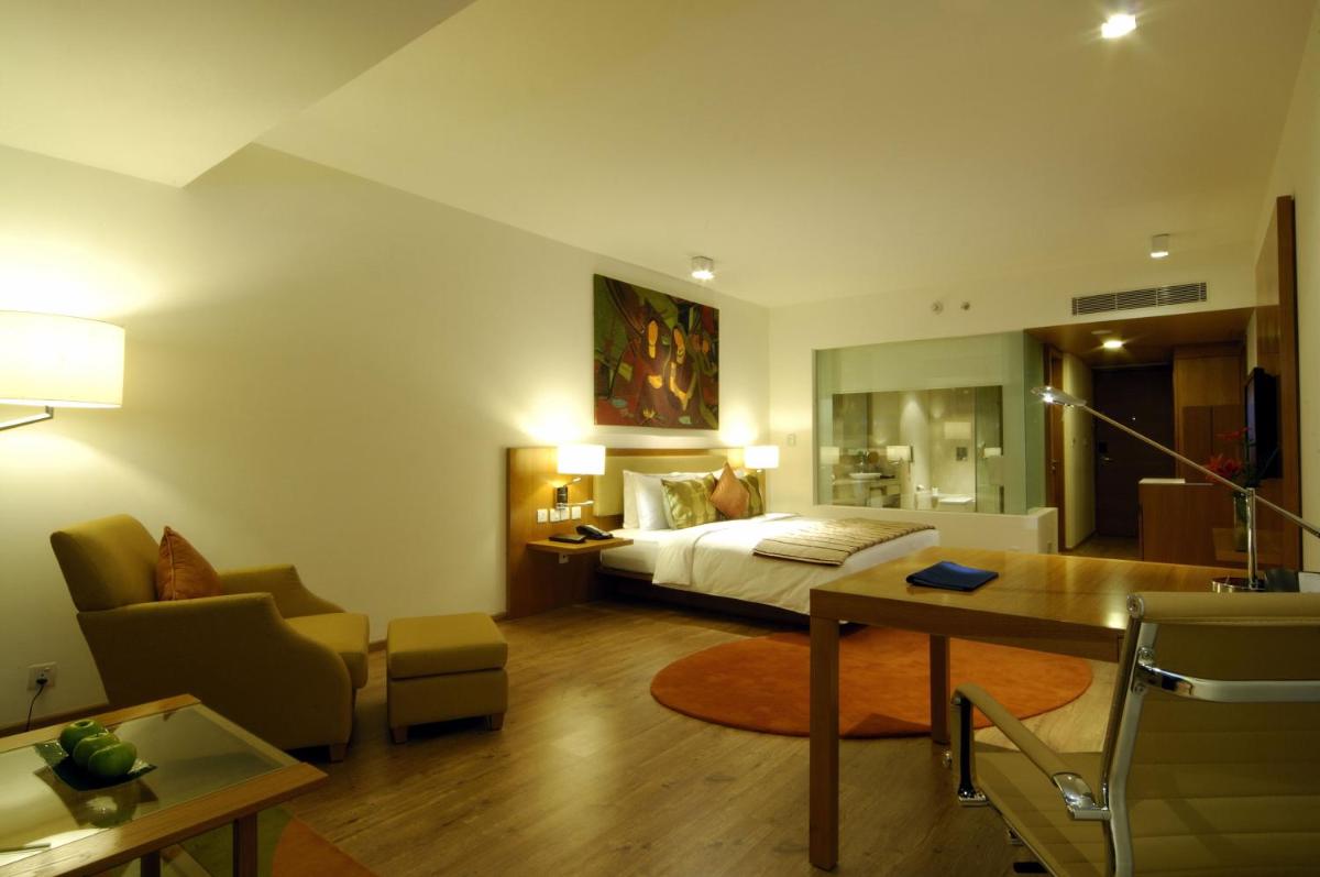 a bedroom with a bed and a living room at Radisson Blu Plaza Hotel Hyderabad Banjara Hills in Hyderabad a bedroom with a bed and a living room at Radisson Blu Plaza Hotel Hyderabad Banjara Hills in Hyderabad