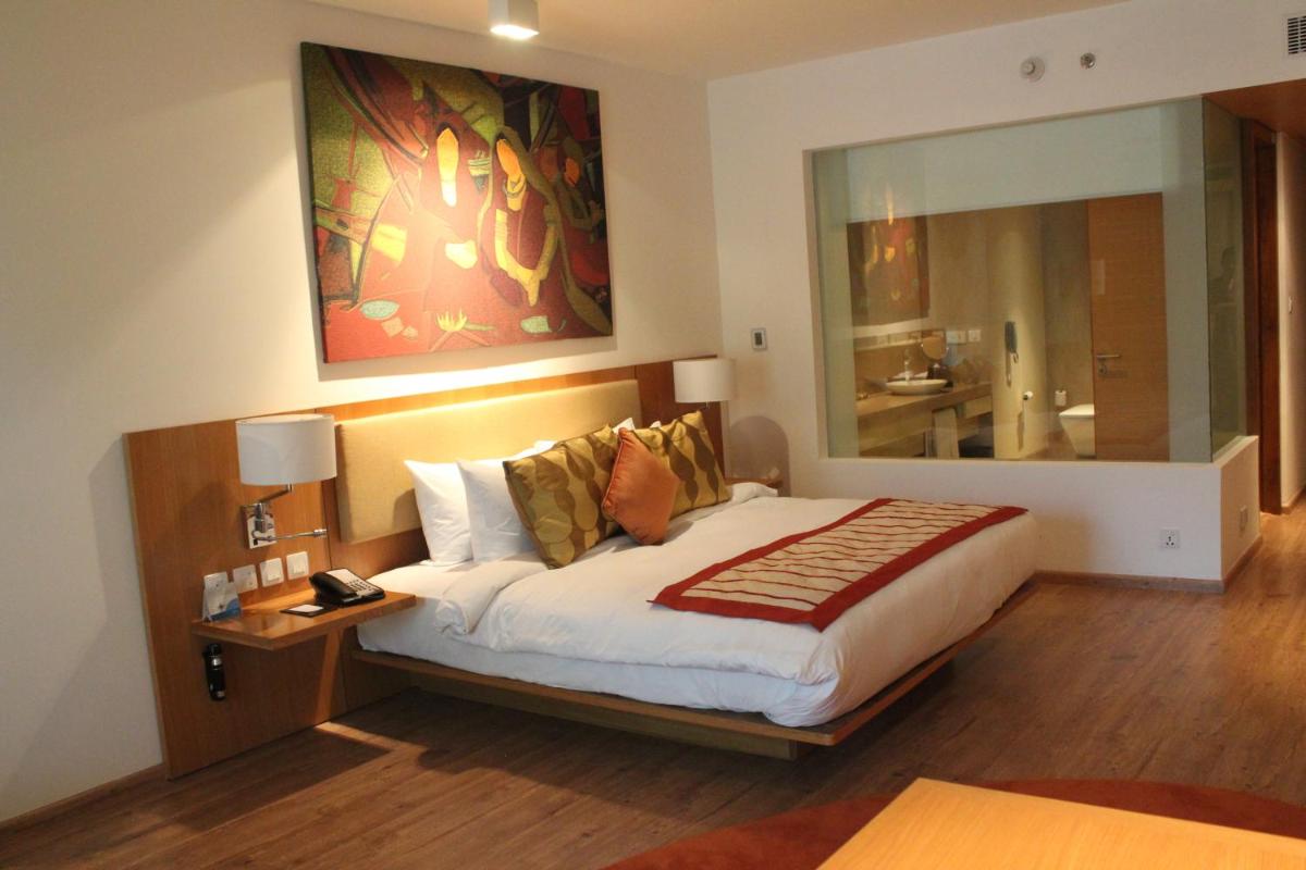 a bedroom with a bed and a large mirror at Radisson Blu Plaza Hotel Hyderabad Banjara Hills in Hyderabad a bedroom with a bed and a large mirror at Radisson Blu Plaza Hotel Hyderabad Banjara Hills in Hyderabad