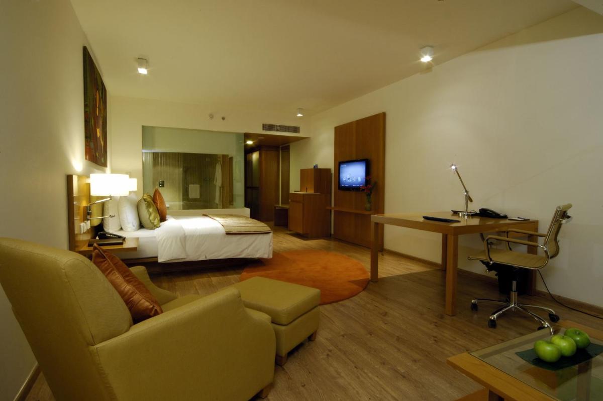 a hotel room with a bed and a living room at Radisson Blu Plaza Hotel Hyderabad Banjara Hills in Hyderabad a hotel room with a bed and a living room at Radisson Blu Plaza Hotel Hyderabad Banjara Hills in Hyderabad
