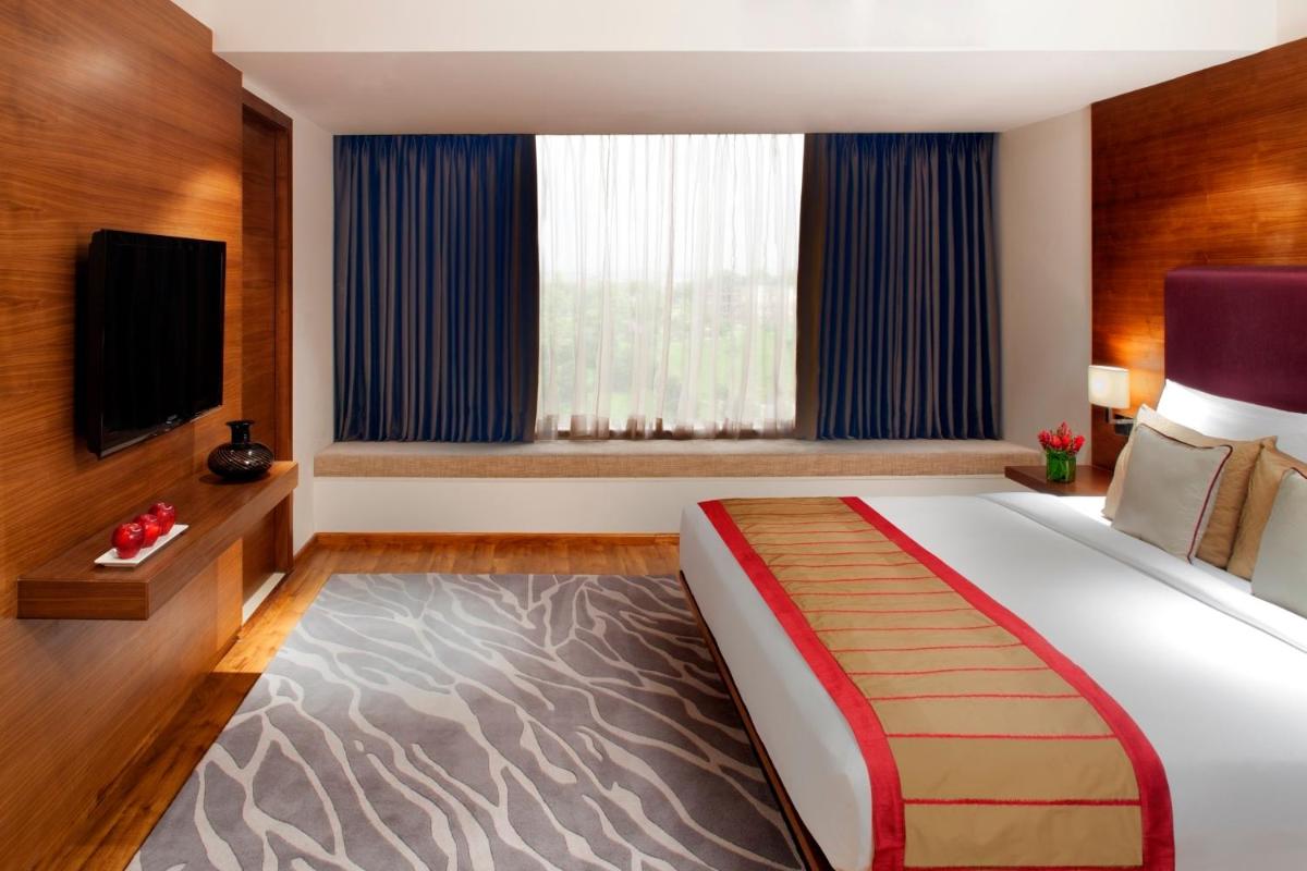 a bedroom with a large bed and a tv at Radisson Blu Plaza Hotel Hyderabad Banjara Hills in Hyderabad a bedroom with a large bed and a tv at Radisson Blu Plaza Hotel Hyderabad Banjara Hills in Hyderabad
