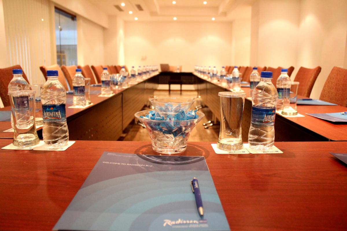 a long table with bottles of water and glasses on it at Radisson Blu Plaza Hotel Hyderabad Banjara Hills in Hyderabad a long table with bottles of water and glasses on it at Radisson Blu Plaza Hotel Hyderabad Banjara Hills in Hyderabad