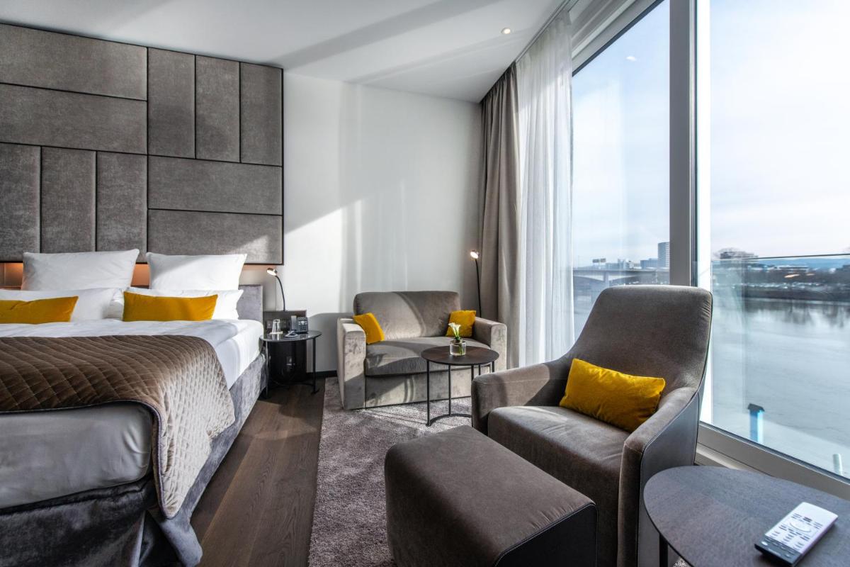 ein Hotelzimmer mit einem Bett und einem großen Fenster in der Unterkunft FÄHRHAUS Koblenz in Koblenz