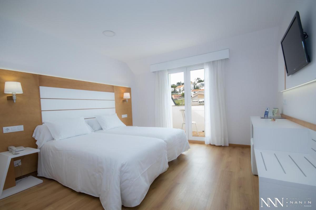 Cama o camas de una habitación en Hotel Spa Nanin Playa
