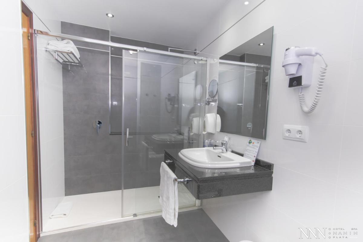 un baño con ducha y lavabo en Hotel Spa Nanin Playa, en Sanxenxo