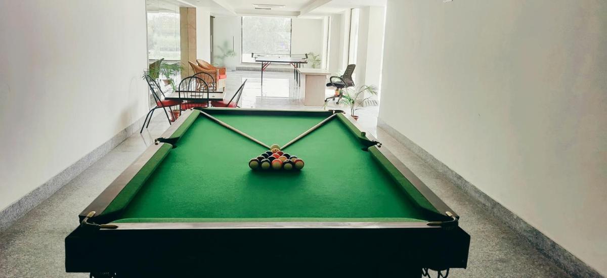 a pool table with a ball on top of it at Ramada by Wyndham Lucknow Hotel and Convention Center in Lucknow