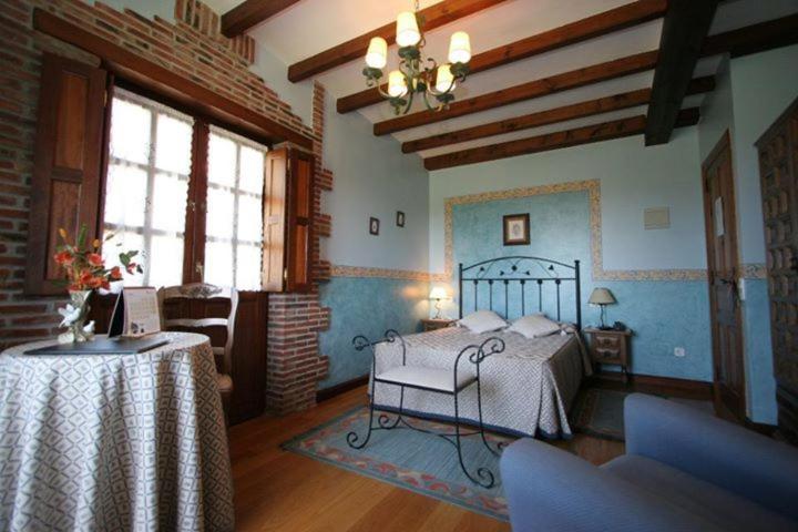 Un dormitorio con una cama y una mesa dentro. en Hotel "Posada de Cantabria EL SOLAR" -Cenas típicas y Gintonic- Bar -Terraza panorámica, en Galizano