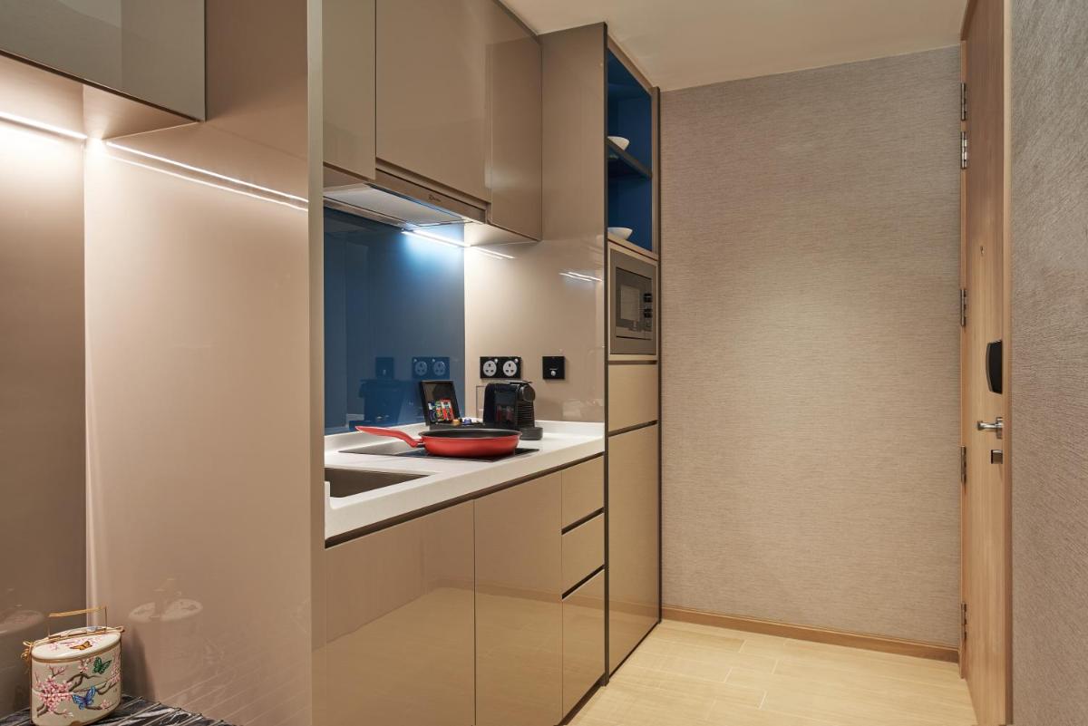 a kitchen with white cabinets and a sink at Capri by Fraser China Square, Singapore in Singapore