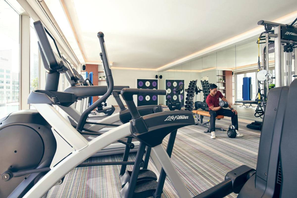 a man sitting on a bench in a gym at Capri by Fraser China Square, Singapore in Singapore