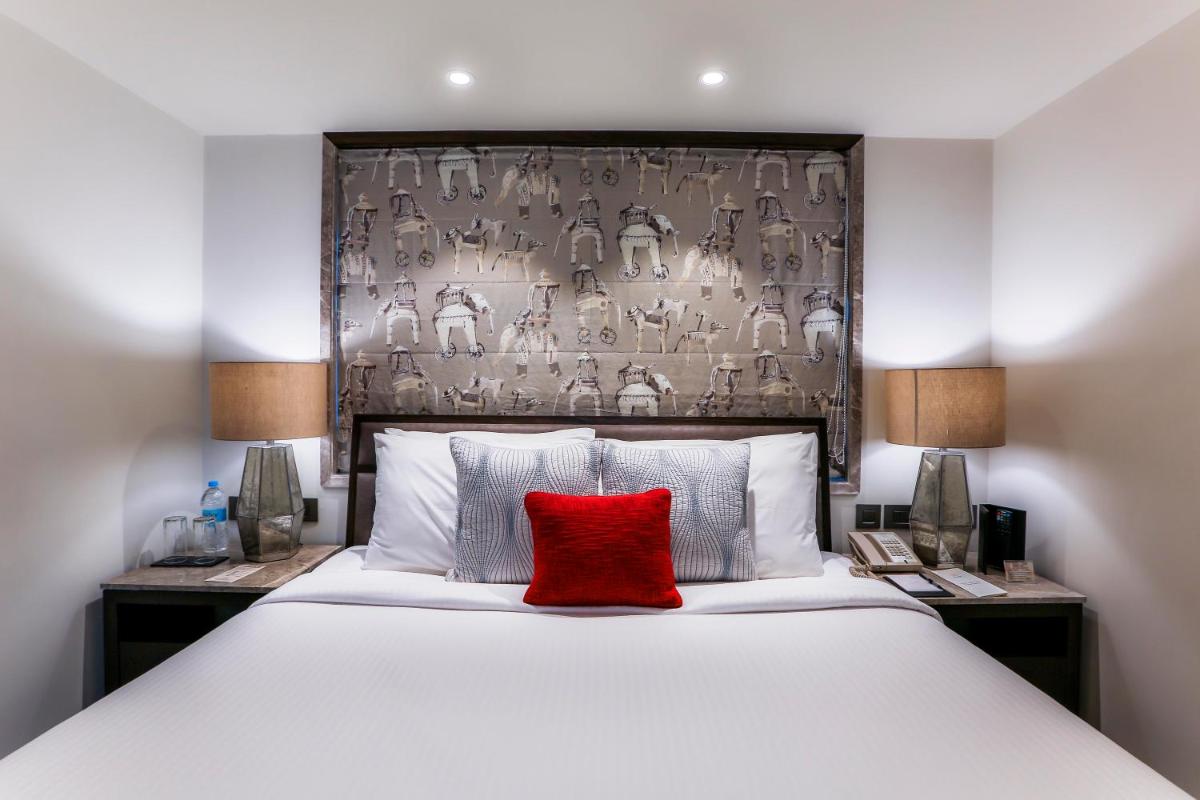 a bedroom with a large bed with a red pillow at Sun-n-Sand Mumbai Juhu Beach in Mumbai