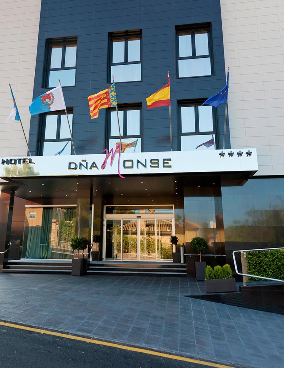 un edificio con banderas en la parte delantera en Dña Monse Hotel Spa & Golf, en Torrevieja