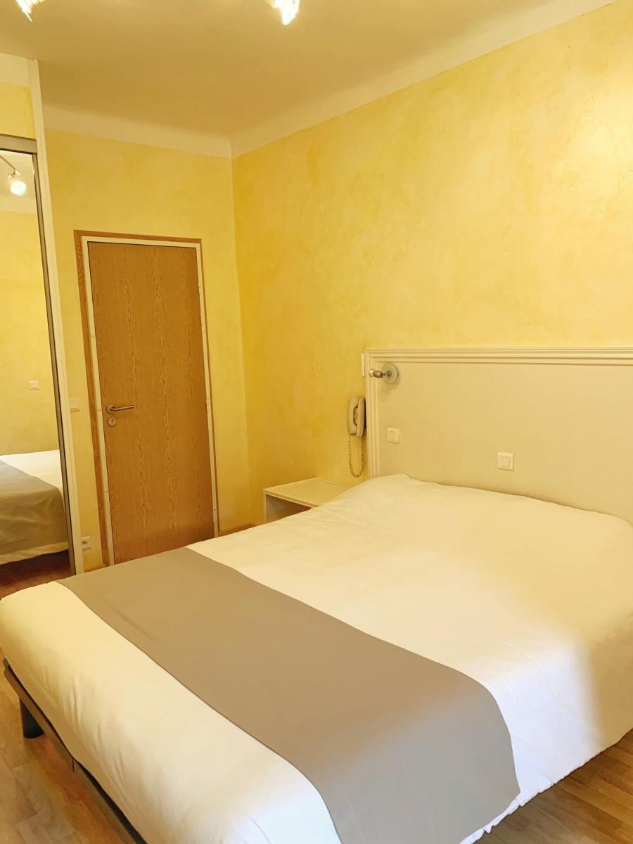 Un ou plusieurs lits dans un hébergement de l'établissement Hôtel Beau Soleil
