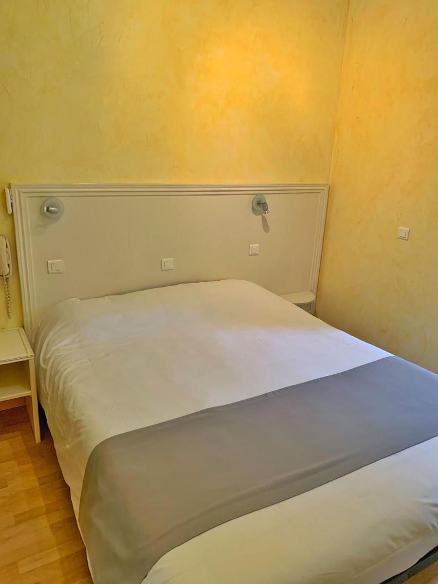 Un ou plusieurs lits dans un hébergement de l'établissement Hôtel Beau Soleil