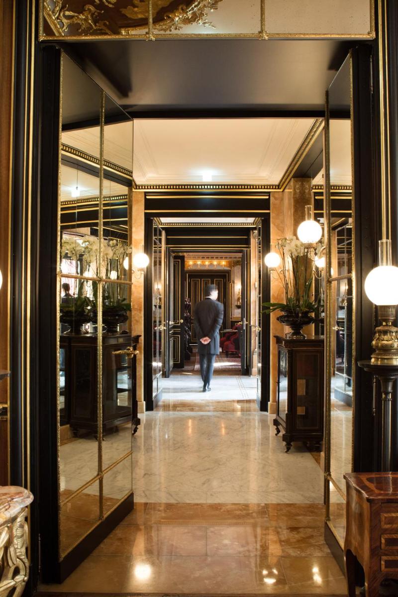 une personne marchant dans un couloir avec un parasol dans l'établissement La Réserve Paris Hotel & Spa, à Paris 114 autres photos