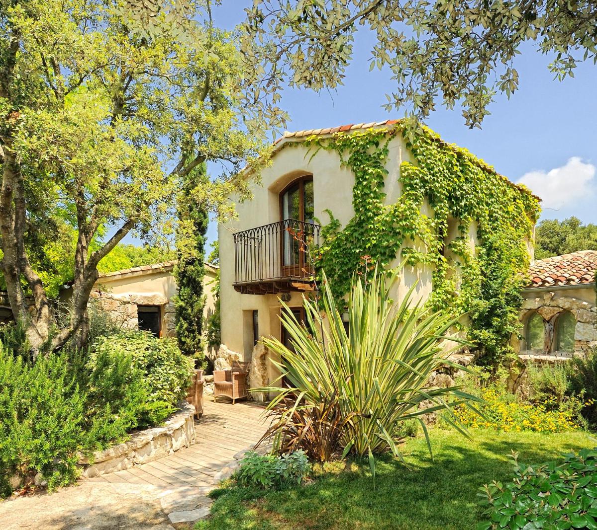 une maison avec un balcon sur le côté dans l'établissement Lodge de Charme A Cheda, à Bonifacio