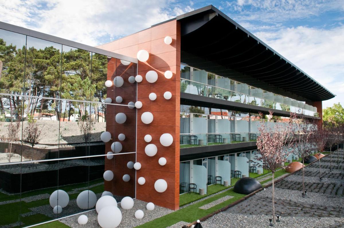 um edifício com esferas brancas na lateral em Evidencia Belverde Hotel em Amora um edifício com esferas brancas na lateral em Evidencia Belverde Hotel em Amora