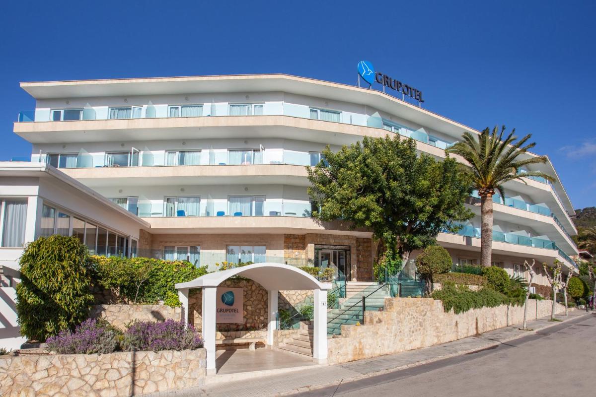Un edificio blanco con una palmera delante. en Grupotel Nilo & Spa, en Paguera
