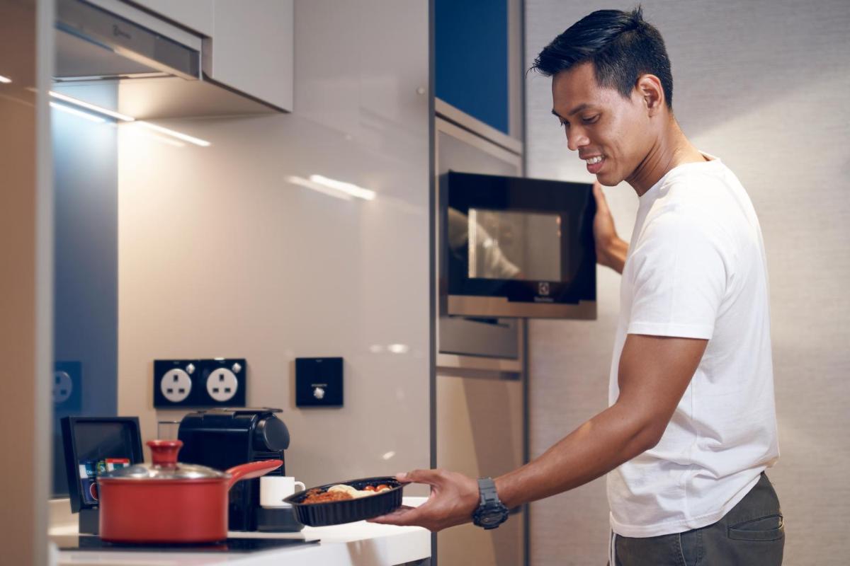 a man holding a plate of food in a kitchen at Capri by Fraser China Square, Singapore in Singapore a man holding a plate of food in a kitchen at Capri by Fraser China Square, Singapore in Singapore