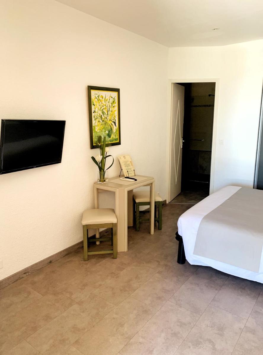 Télévision ou salle de divertissement dans l'établissement Hôtel Beau Soleil