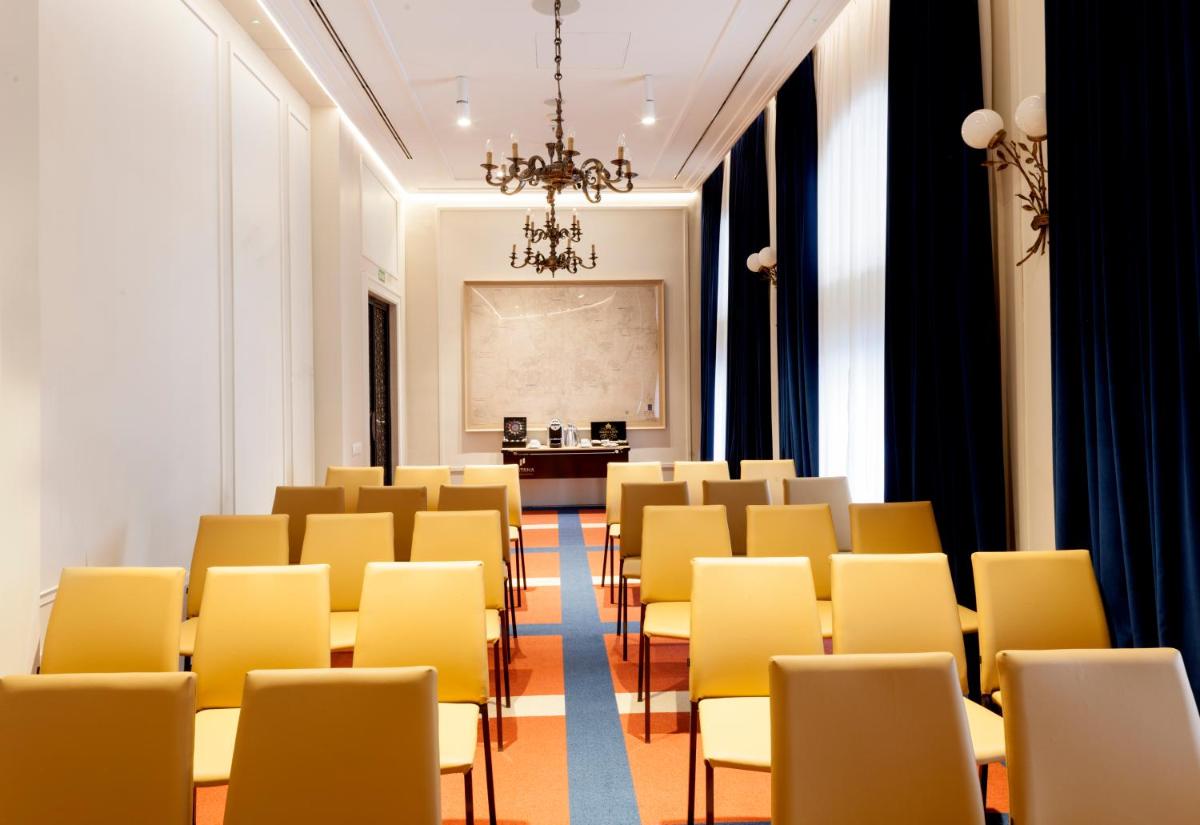 Una habitación con sillas amarillas y una mesa. en Pestana Collection Plaza Mayor, en Madrid 67 fotos más