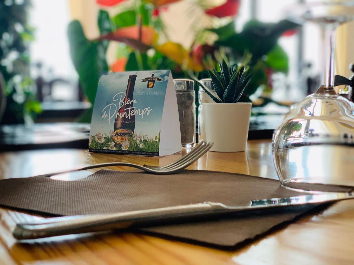 un livre assis au-dessus d'une table en bois dans l'établissement Hôtel Le Belvedere, à Saint-Cyprien