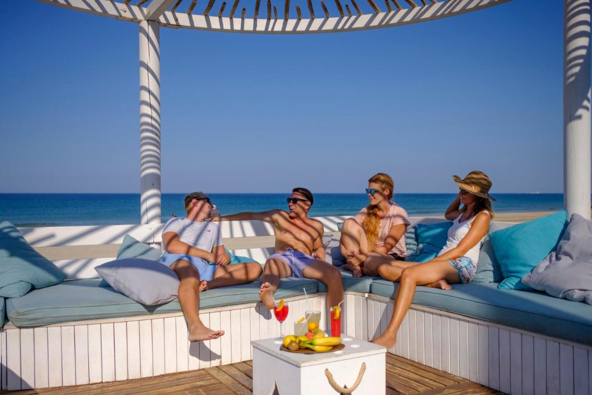 un grupo de personas sentadas en un sofá en la playa en Aldiana Club Andalusien, en Chiclana de la Frontera