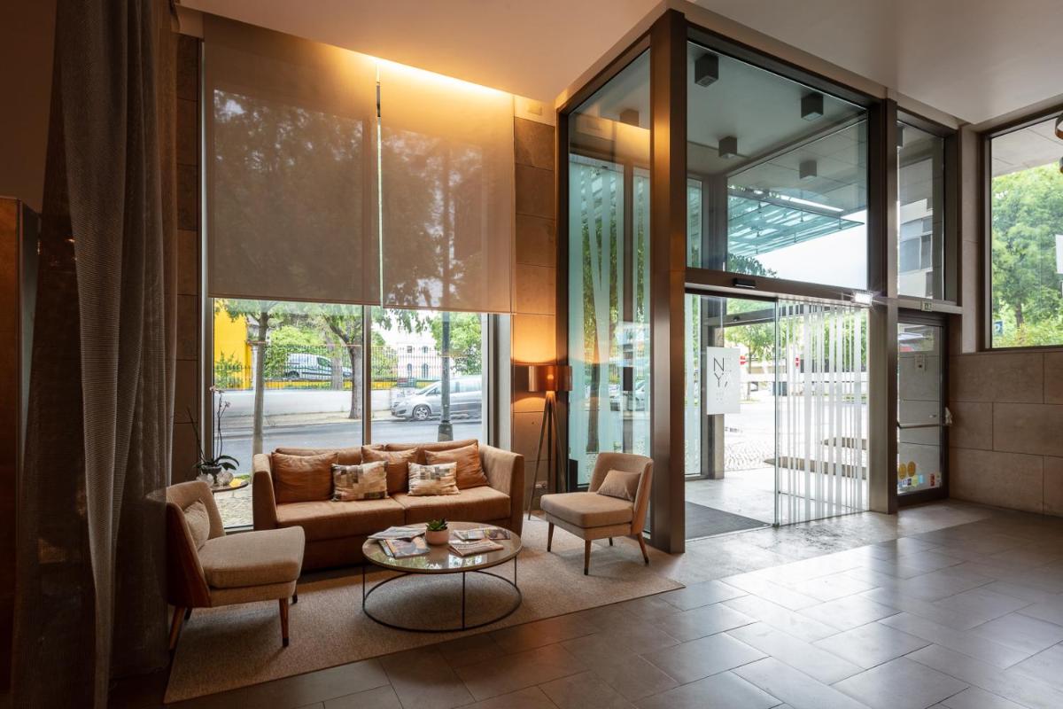 uma sala de estar com um sofá, duas cadeiras e uma mesa em NEYA Lisboa Hotel em Lisboa