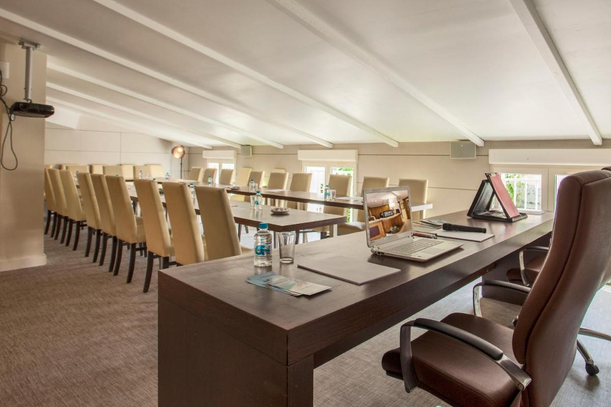 une salle de conférence avec une longue table et des chaises dans l'établissement Le Neptune & Spa, à Propriano