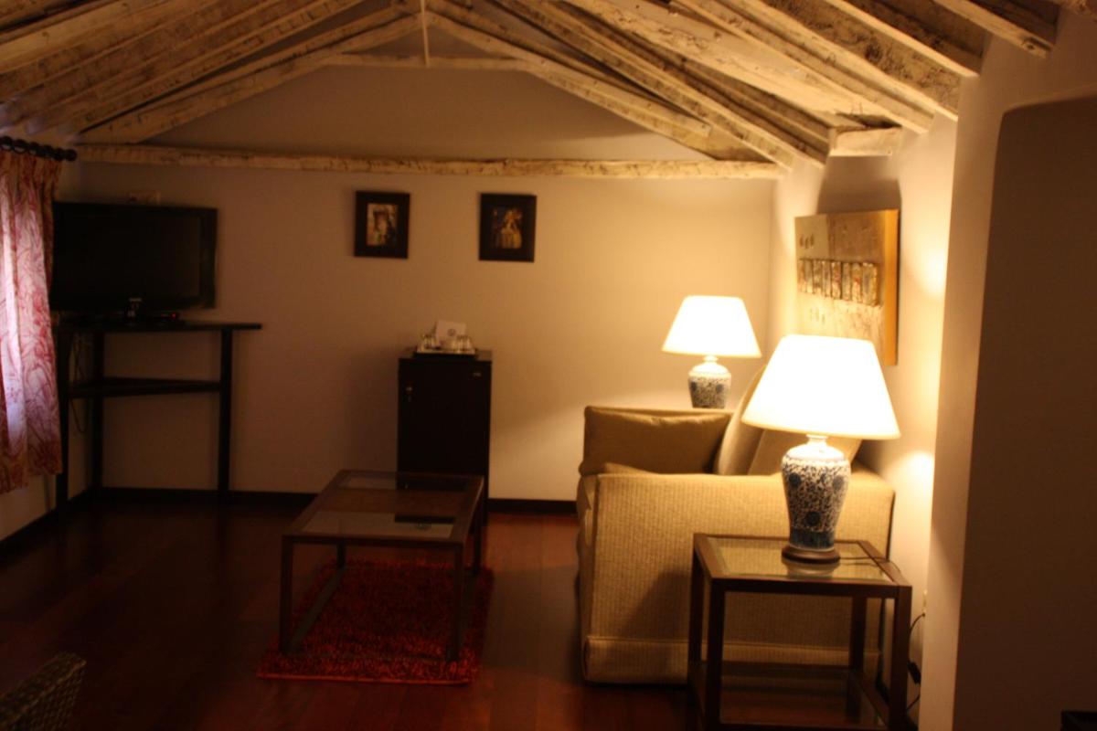 Una sala de estar con un sofá y un televisor. en Hotel Spa La Casa Del Convento, en Chinchón