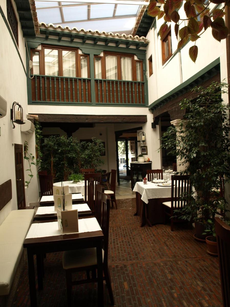 Un restaurante con mesas y sillas y un balcón. en Hotel Spa La Casa Del Convento, en Chinchón