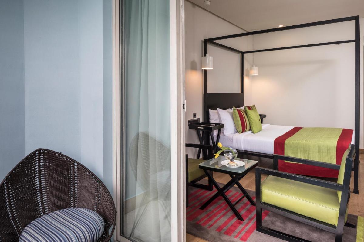 a bedroom with a bed and a chair and a table at The Park Bangalore, MG Road in Bengaluru a bedroom with a bed and a chair and a table at The Park Bangalore, MG Road in Bengaluru