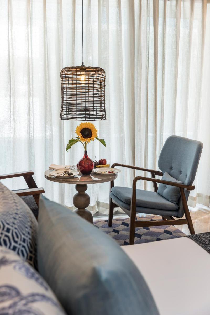 a living room with a table and a chair and a lamp at The Park Bangalore, MG Road in Bengaluru a living room with a table and a chair and a lamp at The Park Bangalore, MG Road in Bengaluru