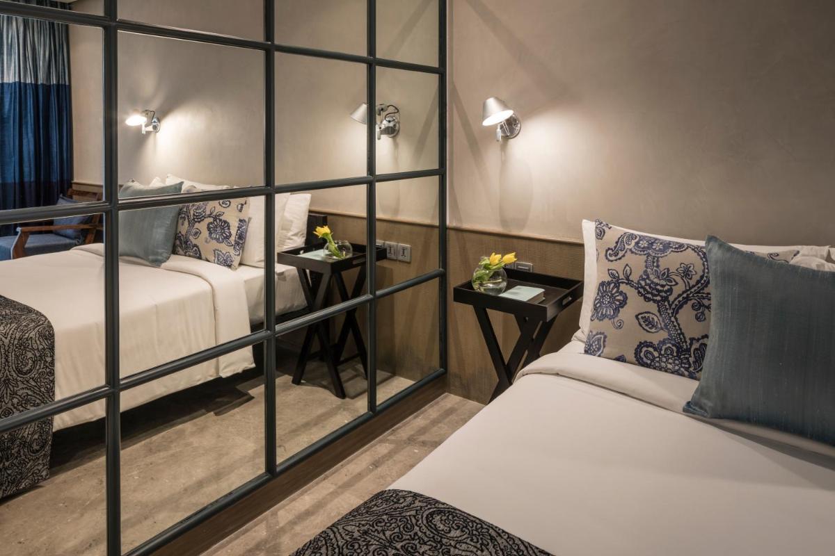 a hotel room with two beds and a glass wall at The Park Bangalore, MG Road in Bengaluru a hotel room with two beds and a glass wall at The Park Bangalore, MG Road in Bengaluru