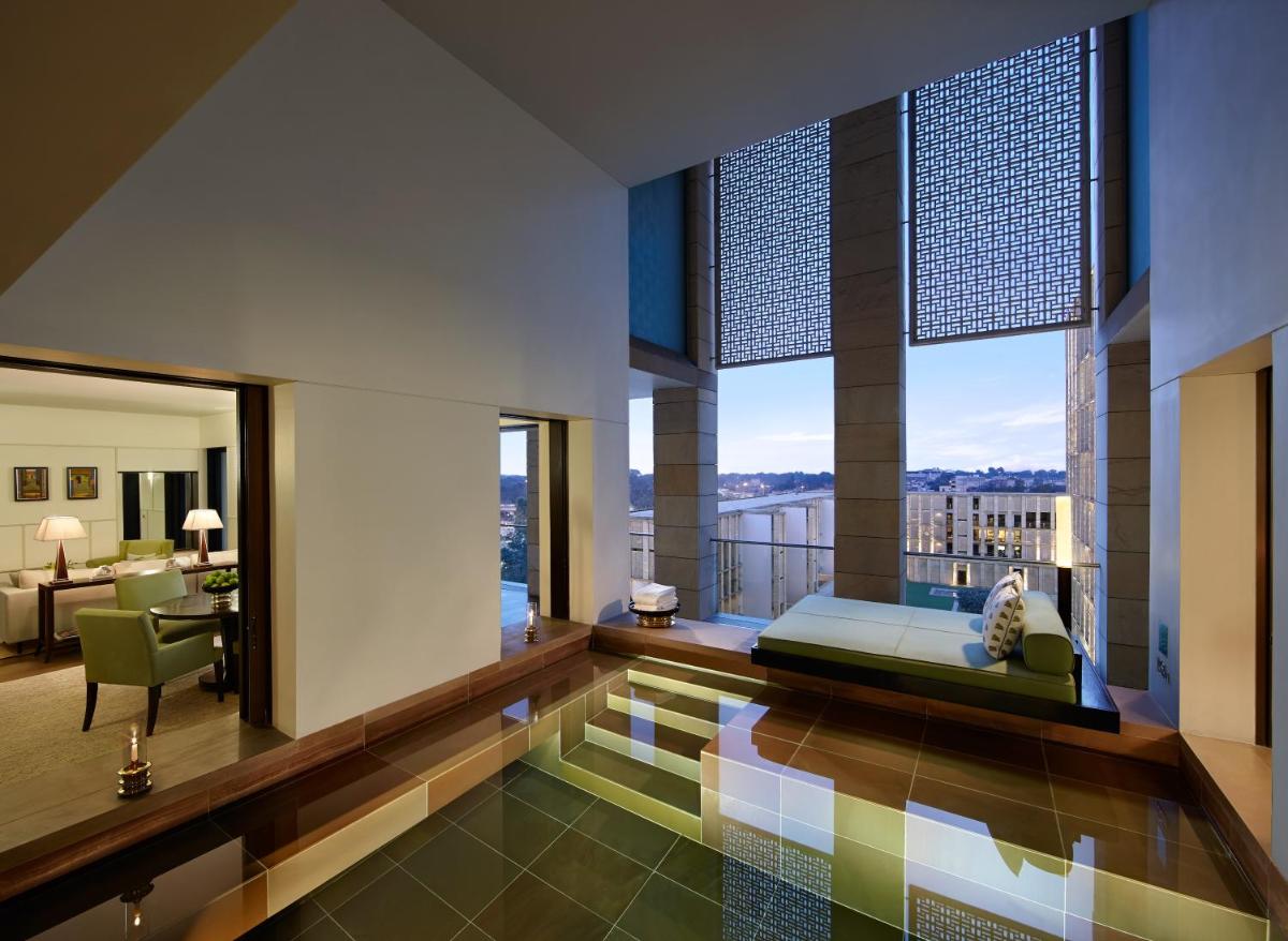 a bedroom with a bed and a balcony with a view at The Lodhi – A member of The Leading Hotels Of The World in New Delhi