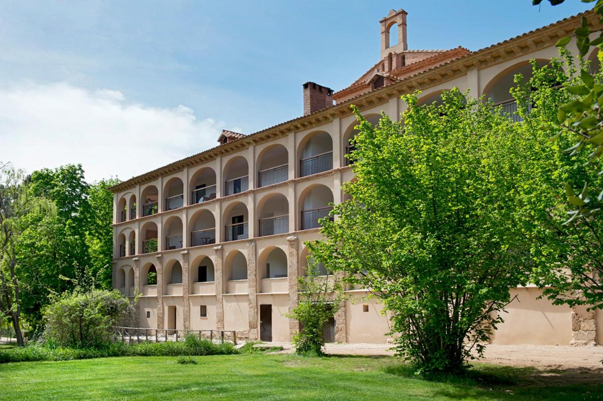 Un edificio antiguo con un árbol delante. en Monasterio De Piedra, en Nuévalos