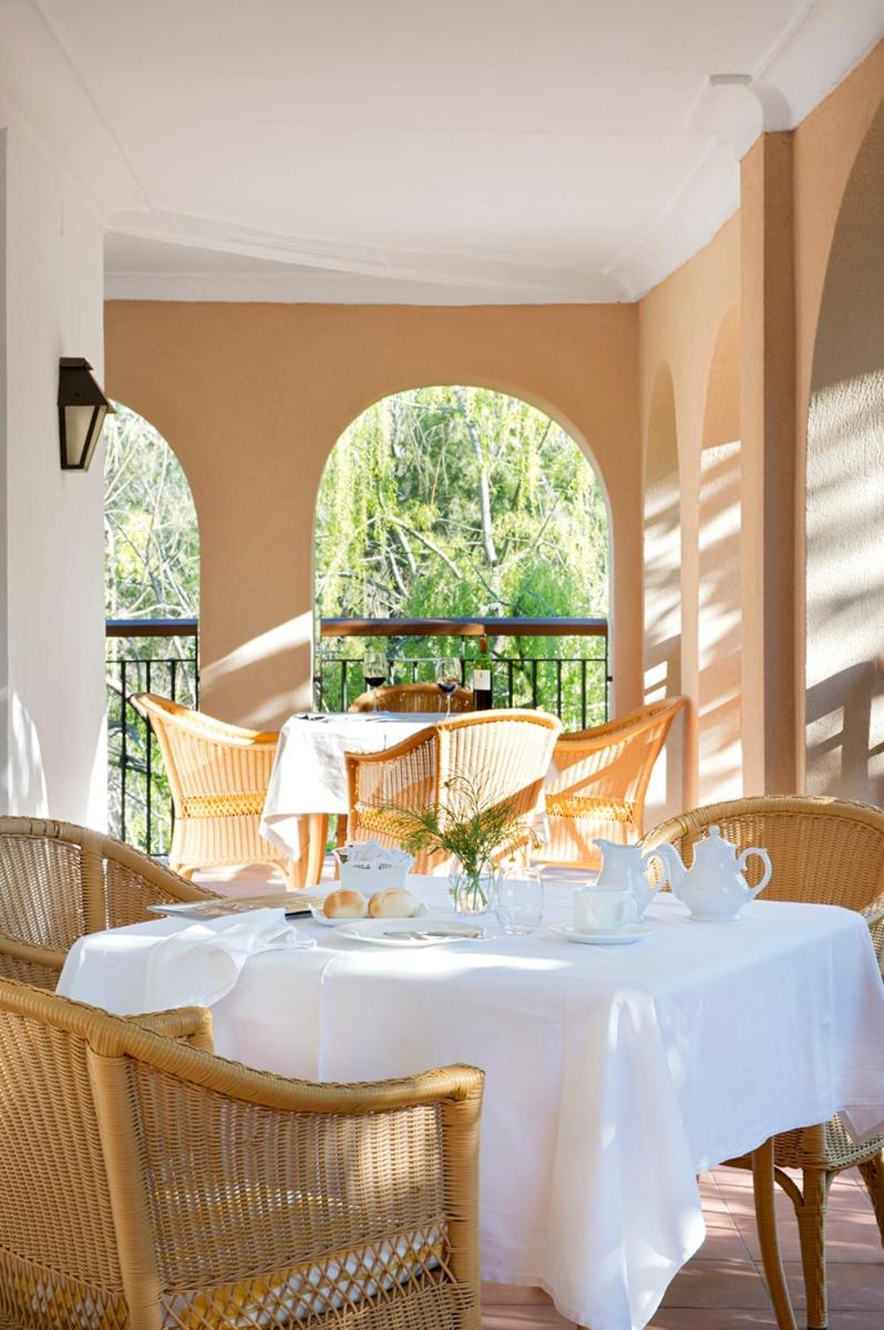 Un comedor con una mesa y sillas blancas. en Monasterio De Piedra, en Nuévalos