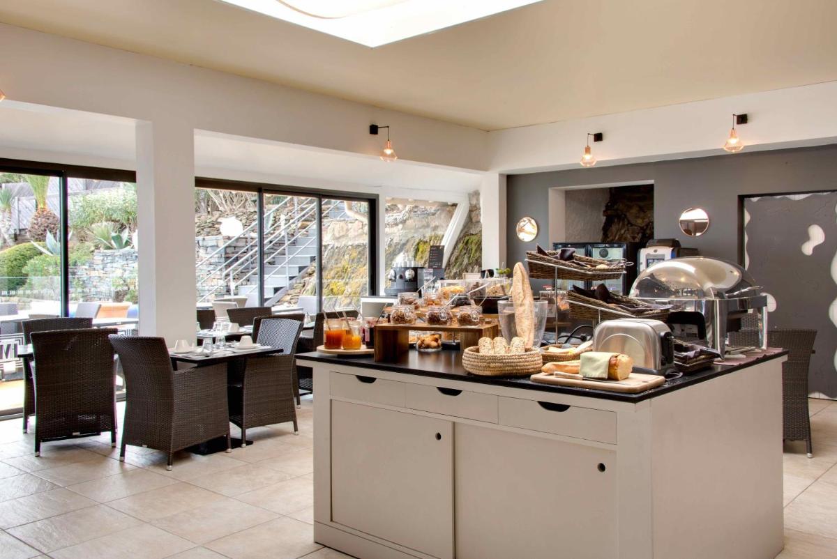 un restaurant avec un comptoir où vous pourrez manger dans l'établissement Hôtel & Spa Les Mouettes, à Argelès-sur-Mer
