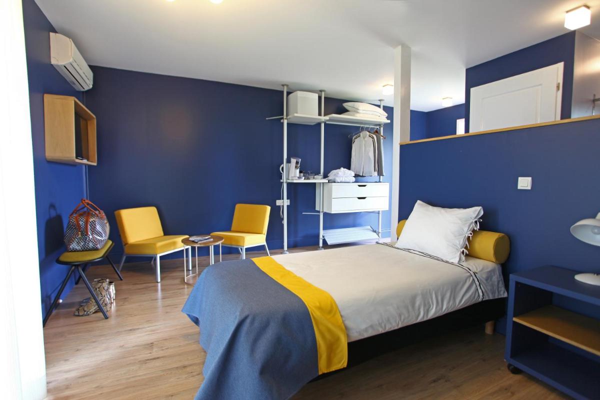 une chambre avec un lit, une table et des chaises dans l'établissement La Petite Couronne, Ecolodge & Lofts, à Saint-Cricq-Chalosse 35 autres photos