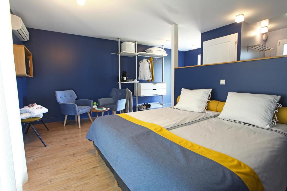 Un ou plusieurs lits dans un hébergement de l'établissement La Petite Couronne, Ecolodge & Lofts