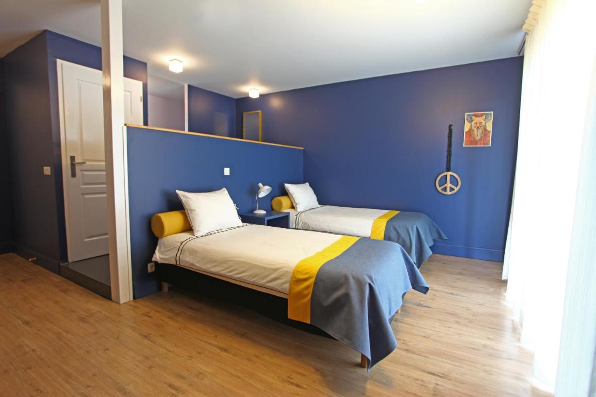 Un ou plusieurs lits dans un hébergement de l'établissement La Petite Couronne, Ecolodge & Lofts