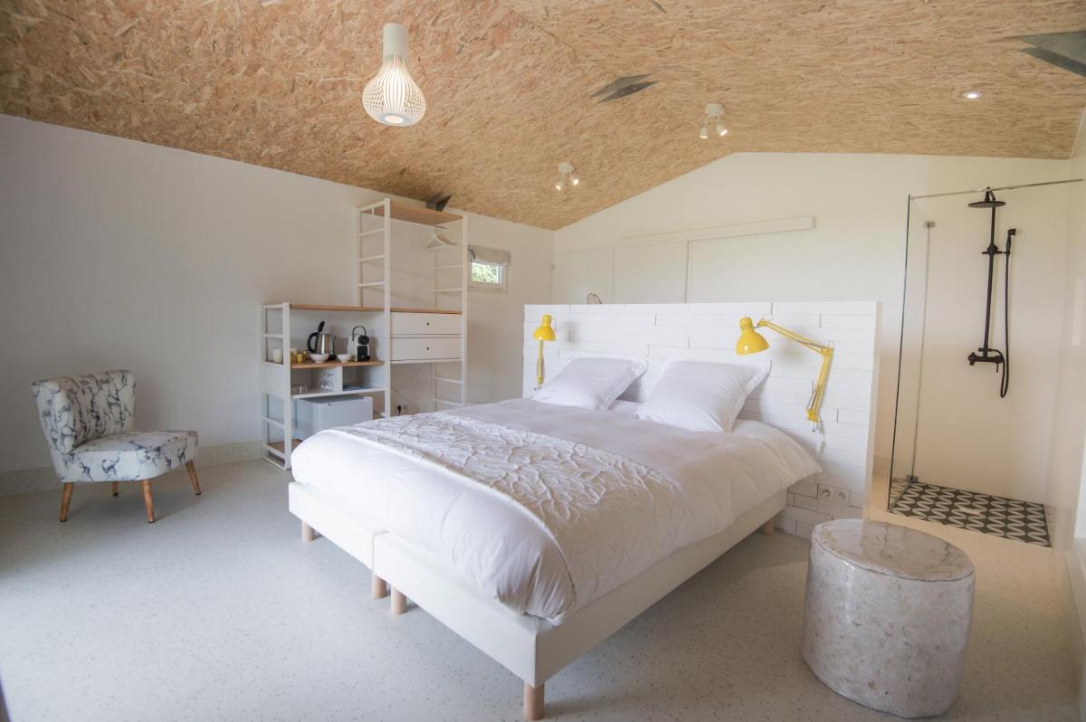 Un ou plusieurs lits dans un hébergement de l'établissement La Petite Couronne, Ecolodge & Lofts
