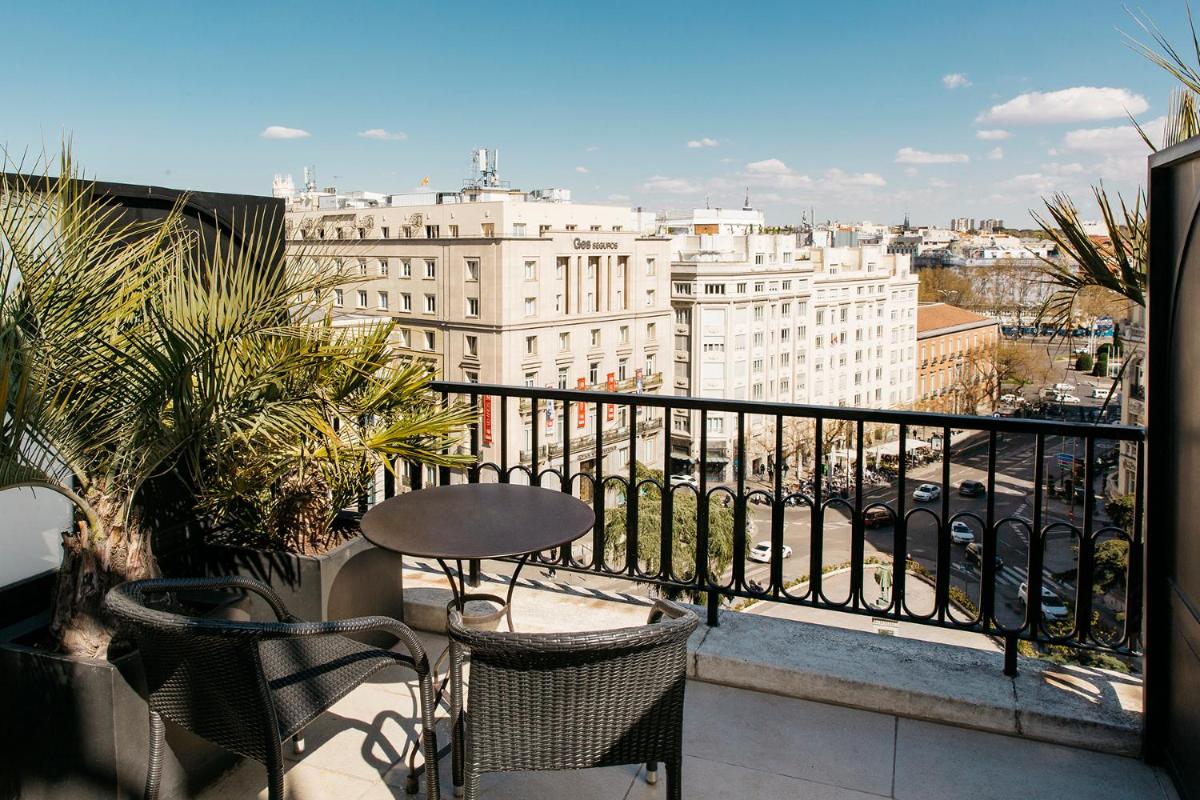 Un balcón con una mesa y sillas y una ciudad. en Hotel Villa Real, a member of Preferred Hotels & Resorts, en Madrid