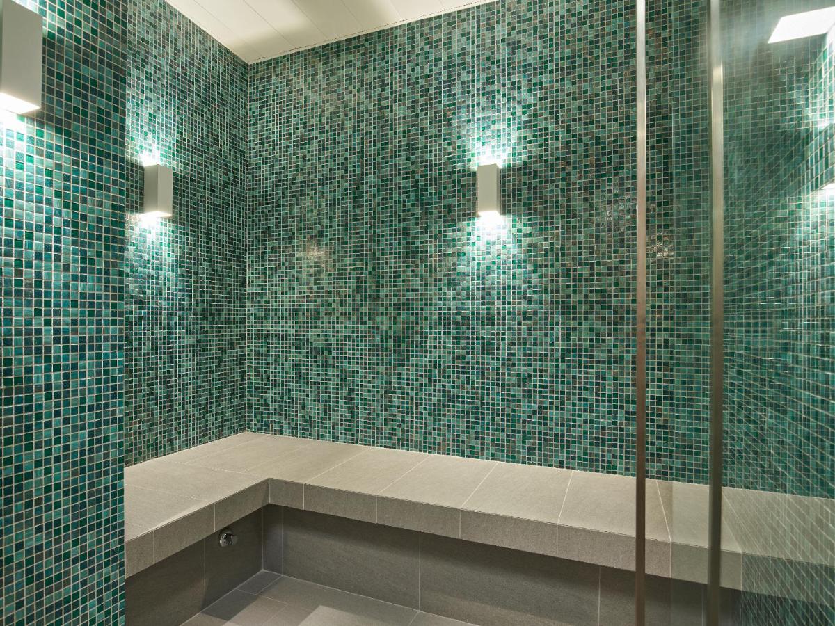 a green tiled bathroom with a shower with two lights at Capri by Fraser China Square, Singapore in Singapore