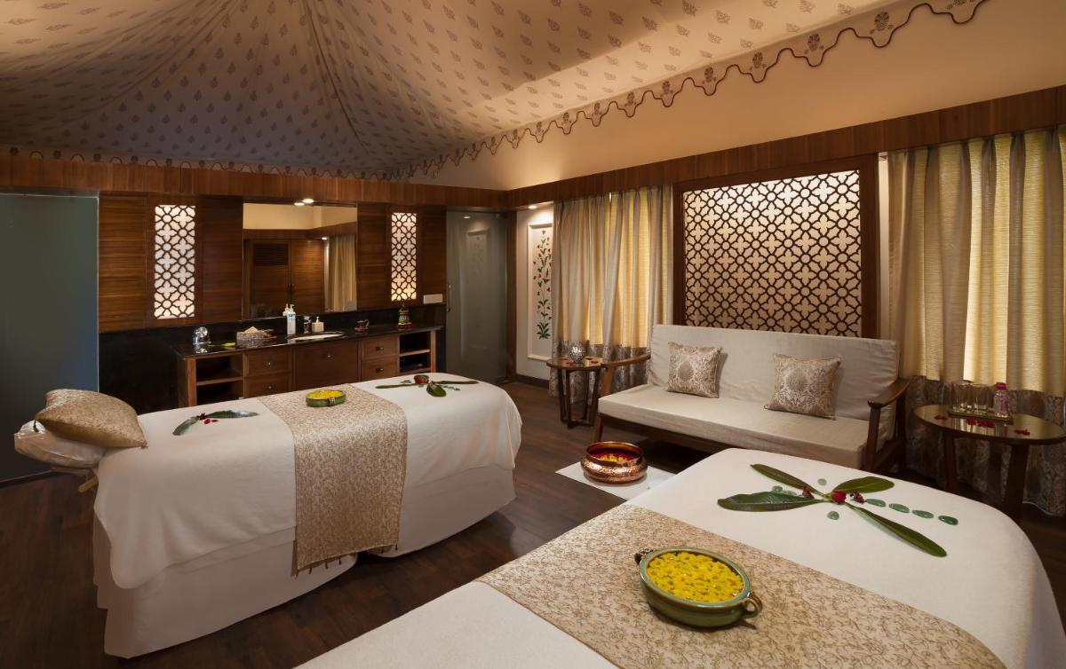 a bedroom with two beds and a living room at Jai Mahal Palace in Jaipur