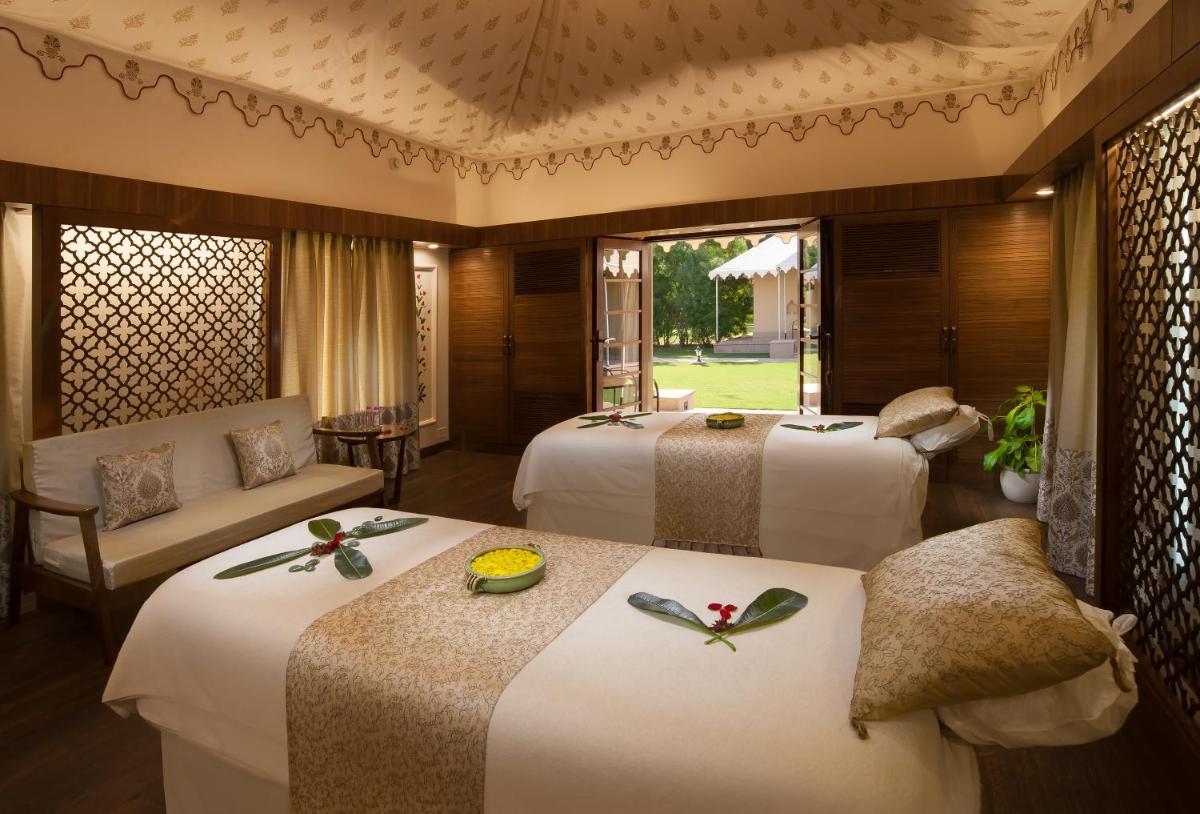 a hotel room with two beds and a couch at Jai Mahal Palace in Jaipur