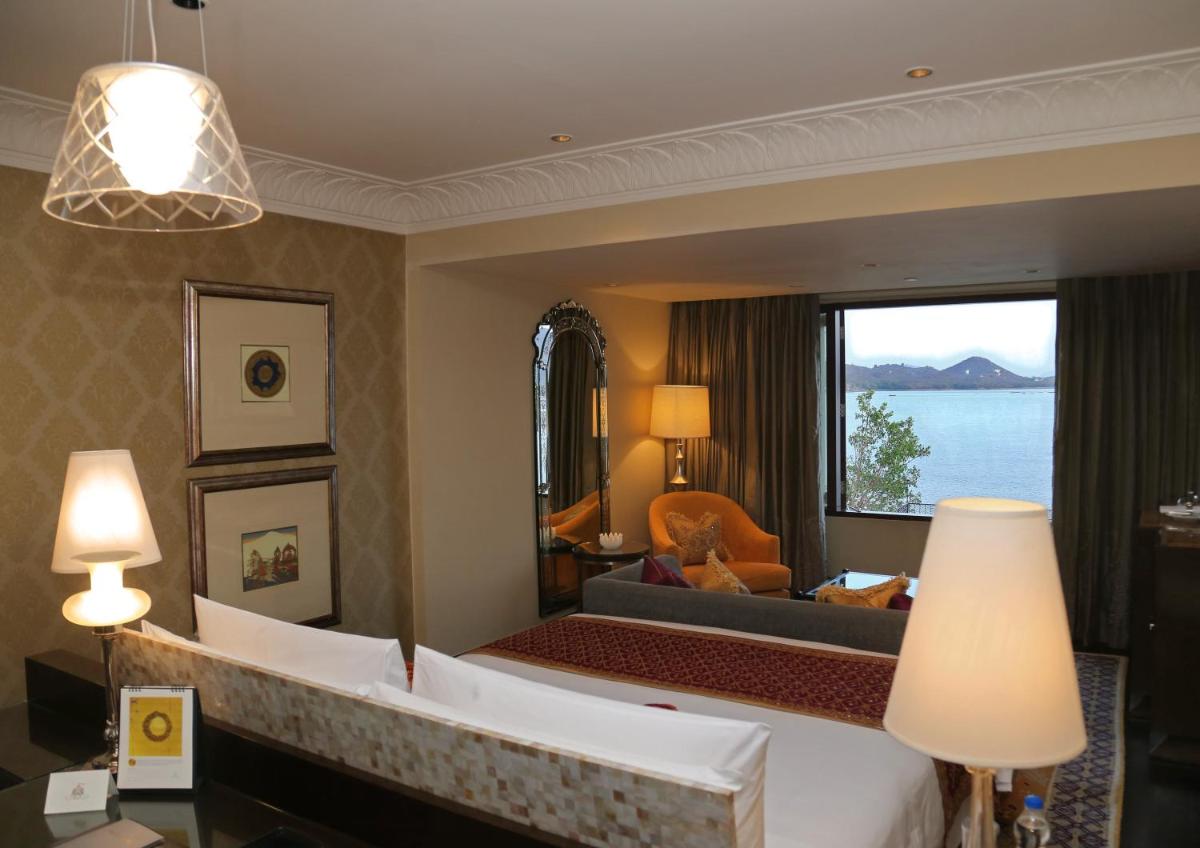 a bedroom with a large mirror in a hotel room at The Leela Palace Udaipur in Udaipur
