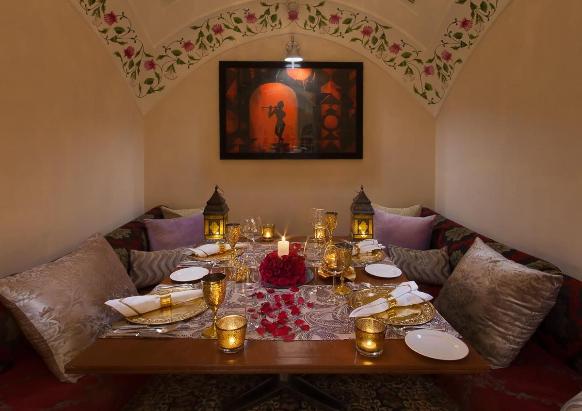 a dining room table with candles and plates on it at Jai Mahal Palace in Jaipur