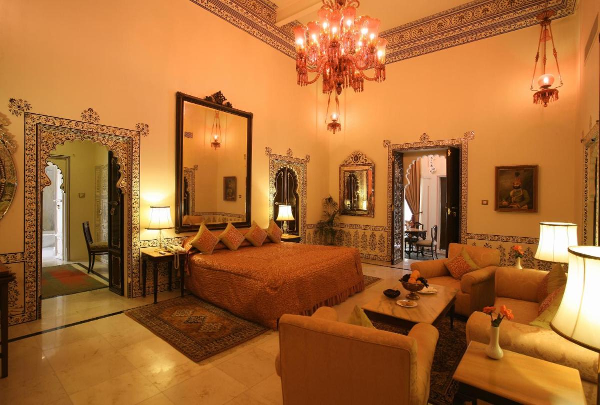 a bedroom with a bed and a living room at Shiv Niwas Palace by HRH Group of Hotels in Udaipur