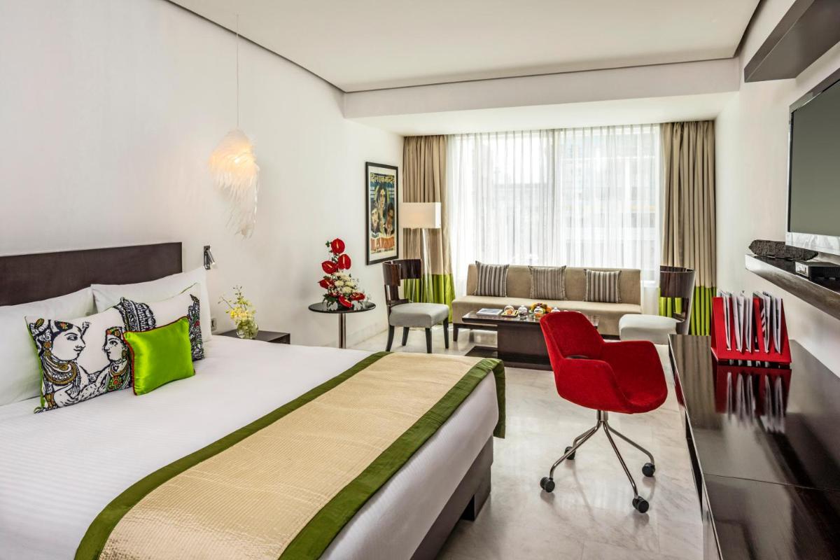 a bedroom with a large bed and a living room at The Park Chennai in Chennai a bedroom with a large bed and a living room at The Park Chennai in Chennai