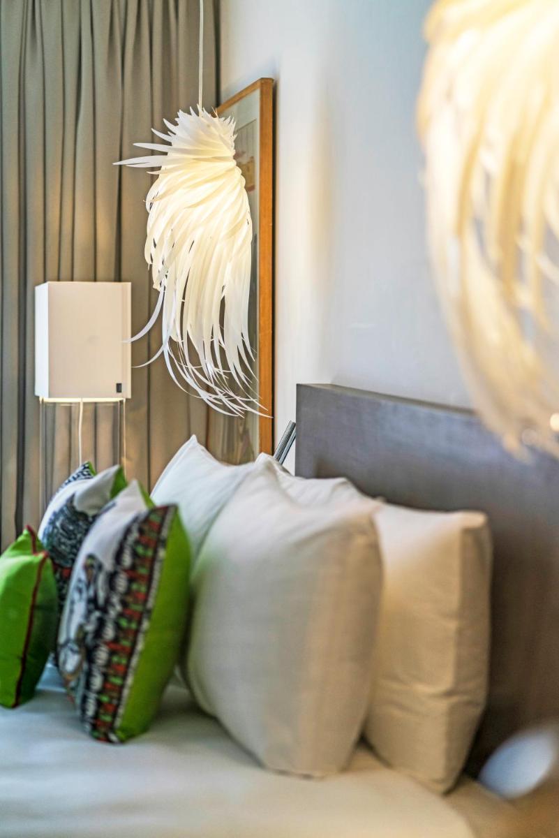 a bedroom with a bed with pillows and a lamp at The Park Chennai in Chennai a bedroom with a bed with pillows and a lamp at The Park Chennai in Chennai